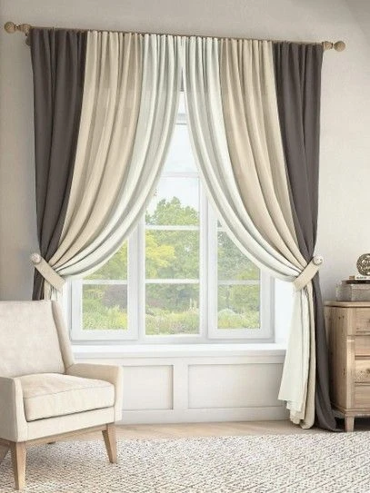 Soft grey and beige curtains pulled back with decorative holdbacks over a large window.