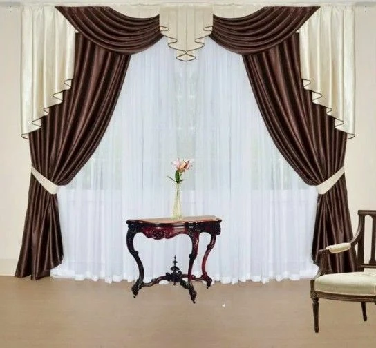 Elegant brown and cream satin curtains with elaborate swags and a white sheer under-layer.