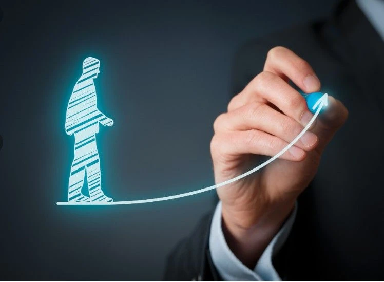 A hand draws a glowing upward arrow with a human silhouette walking along the rising line.