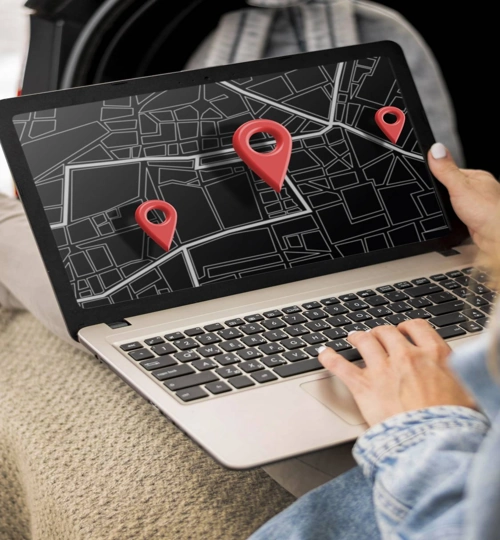 A person uses a laptop displaying a local SEO map with three red location pins.