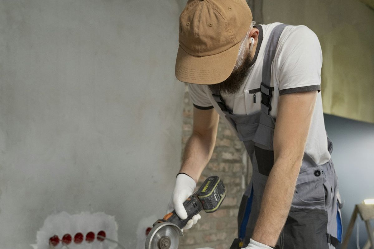 Contractor in work overalls cutting tile on a job site